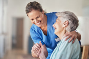 Medical professional and elderly patient embracing each other